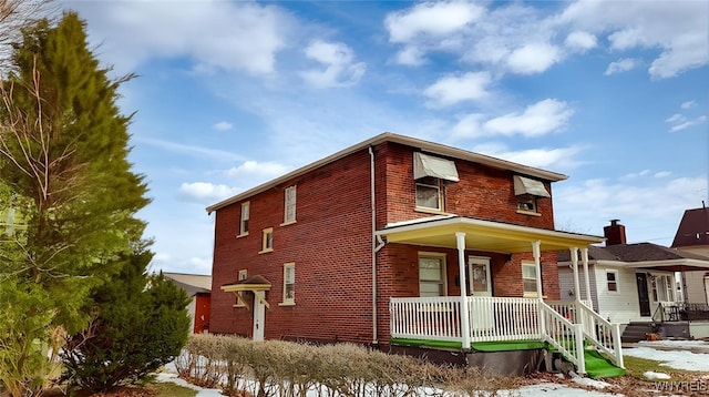 view of front facade featuring covered porch and brick siding