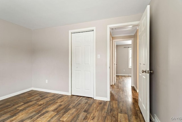 unfurnished bedroom featuring dark wood-style flooring and baseboards