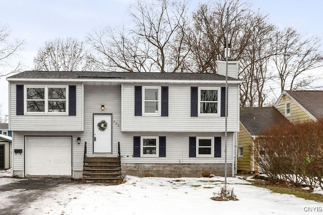 bi-level home featuring a garage and a chimney