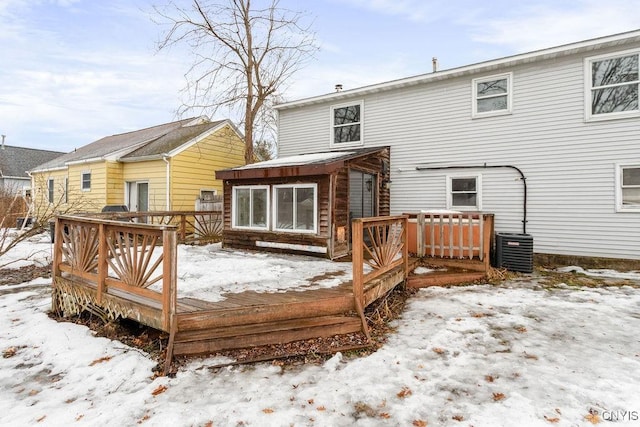 snow covered house featuring a deck and cooling unit