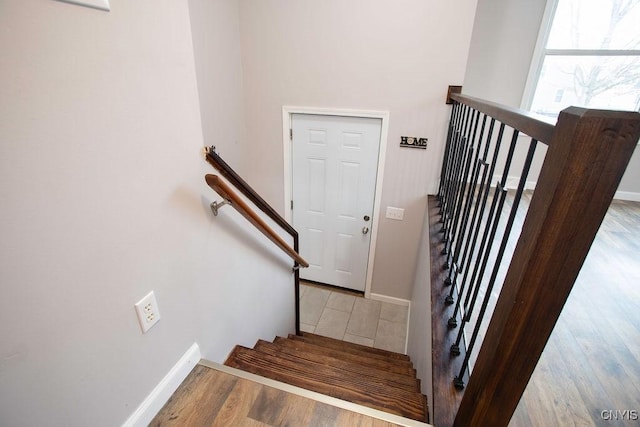 staircase featuring baseboards and wood finished floors