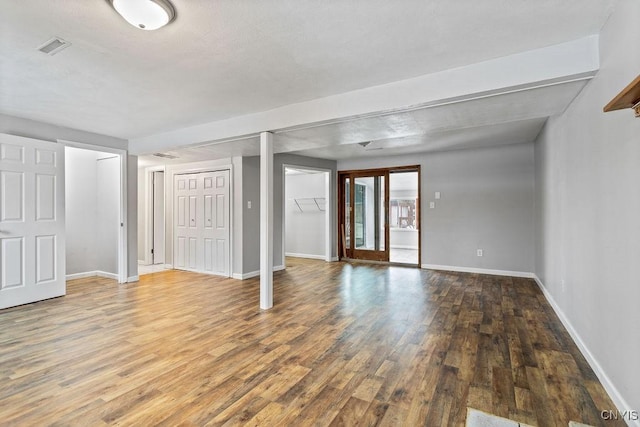 below grade area with visible vents, baseboards, and wood finished floors