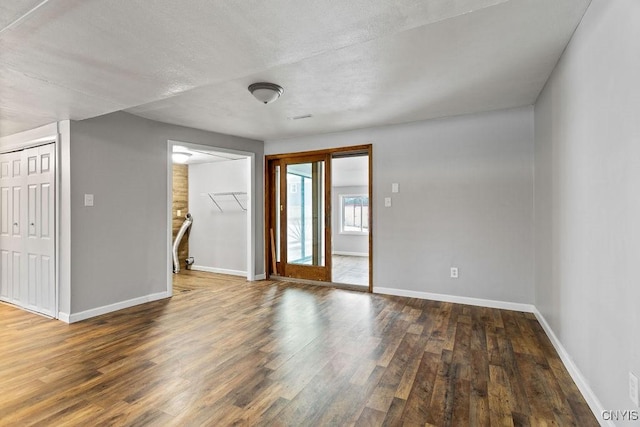 unfurnished room with baseboards and wood finished floors