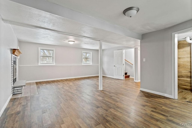 basement featuring baseboards, stairway, and wood finished floors