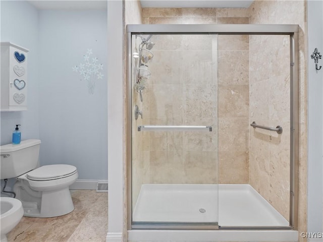 full bath with baseboards, toilet, tile patterned floors, a shower stall, and a bidet