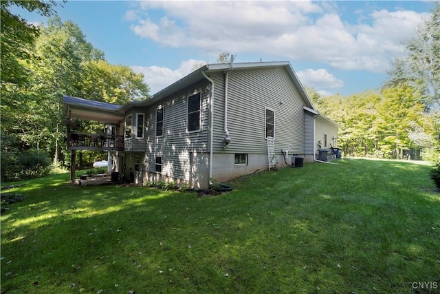 view of side of home with a yard and central AC