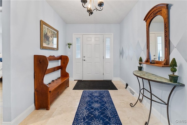 foyer with visible vents, baseboards, and a notable chandelier