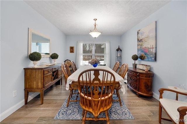 dining room featuring light wood-type flooring and baseboards