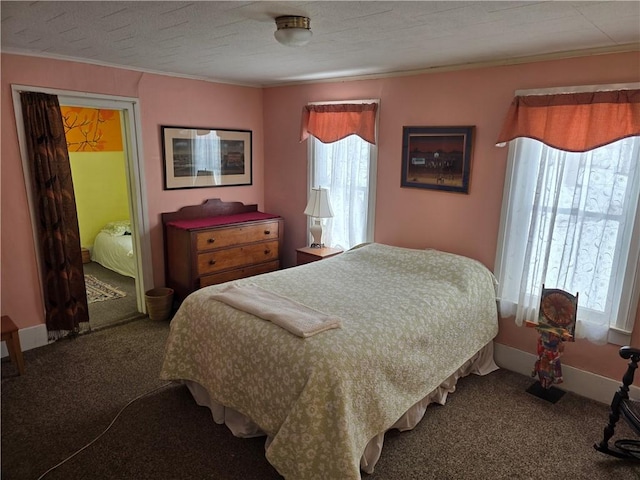 bedroom with a textured ceiling, carpet floors, ornamental molding, and baseboards