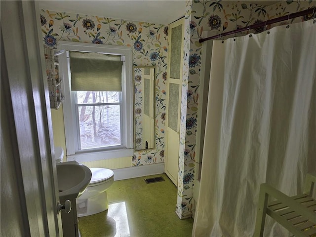 full bath with toilet, a shower with shower curtain, visible vents, baseboards, and wallpapered walls