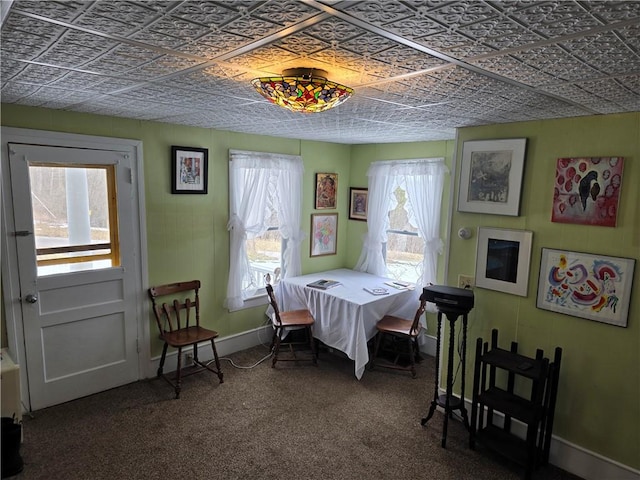 carpeted dining space with an ornate ceiling and baseboards