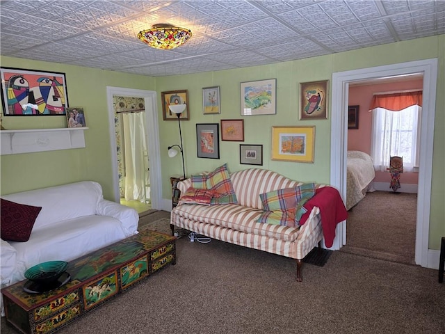 living area featuring carpet floors, an ornate ceiling, and baseboards