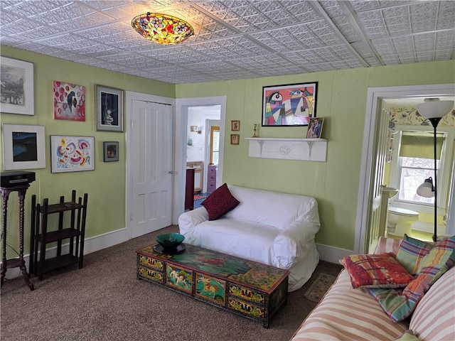 living area with carpet, an ornate ceiling, and baseboards