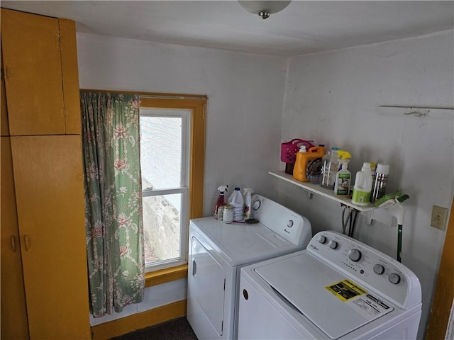 washroom featuring laundry area, baseboards, and washer and clothes dryer