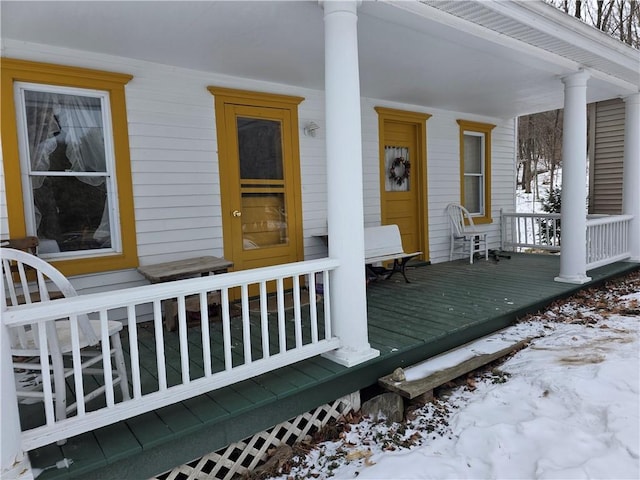 snow covered property entrance with a porch