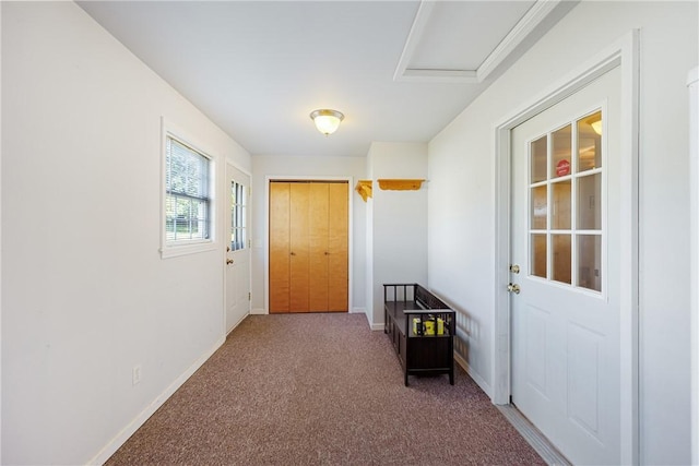 doorway featuring baseboards and carpet flooring