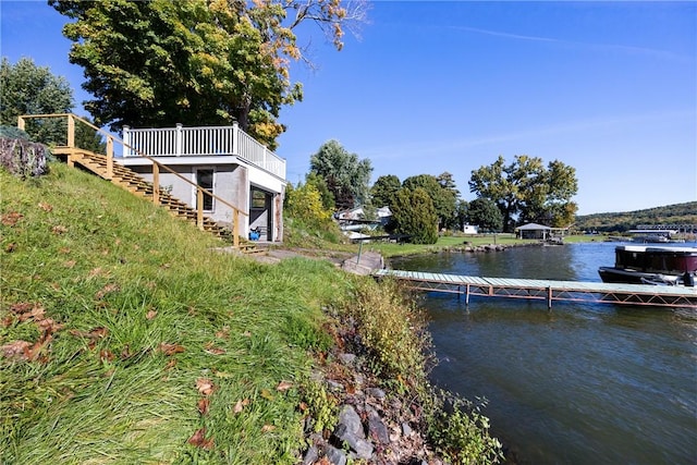 exterior space featuring a dock, a water view, and stairway