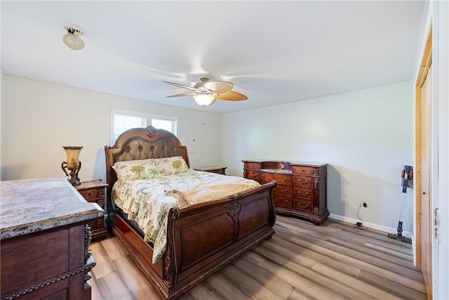 bedroom with light wood-style floors, baseboards, and a ceiling fan