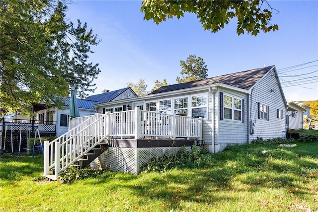 view of front of home with a wooden deck, stairway, and a front yard