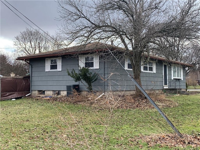 view of front of property featuring cooling unit and a front lawn