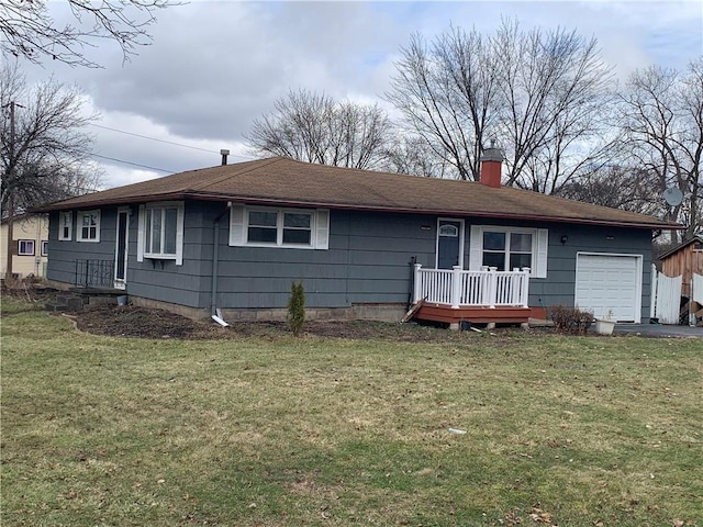 rear view of house with aphalt driveway, a chimney, an attached garage, and a lawn