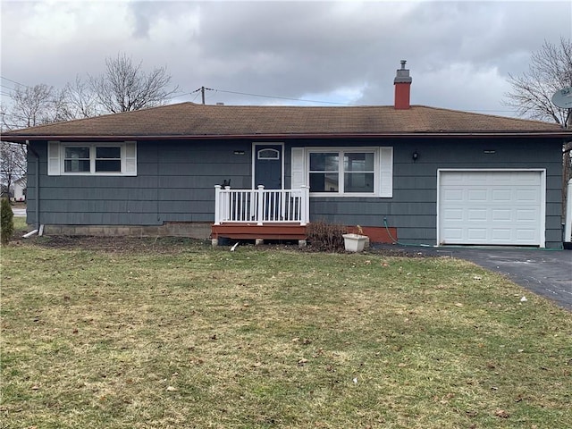 single story home featuring a garage, a chimney, a front lawn, and aphalt driveway