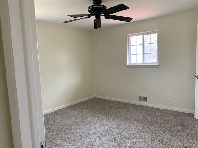 carpeted empty room featuring baseboards, visible vents, and ceiling fan