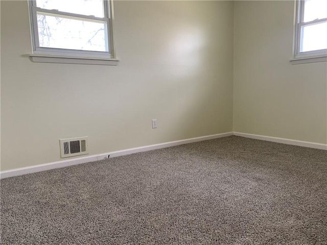 spare room featuring carpet flooring, visible vents, and baseboards