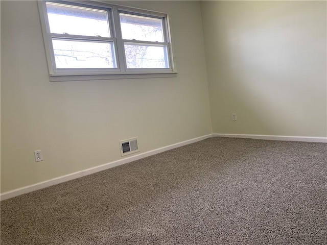 carpeted spare room featuring visible vents and baseboards