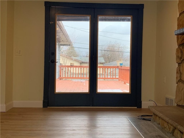 entryway featuring a healthy amount of sunlight, visible vents, baseboards, and wood finished floors