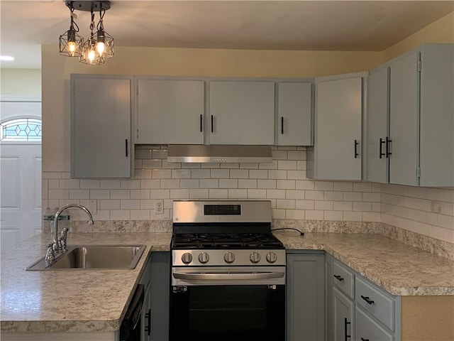 kitchen featuring stainless steel range with gas stovetop, a sink, light countertops, under cabinet range hood, and backsplash