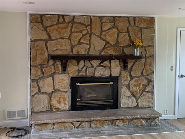 interior details featuring a fireplace, visible vents, and wood finished floors