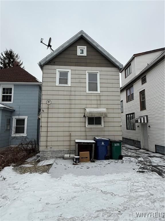 view of snow covered back of property