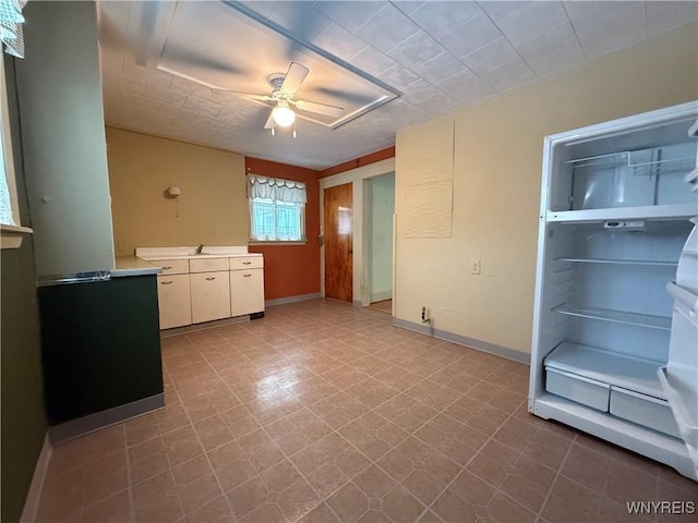 interior space featuring ceiling fan, light countertops, and baseboards