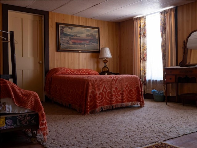 carpeted bedroom with wooden walls