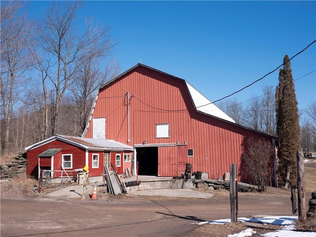 view of property featuring a detached garage and a barn