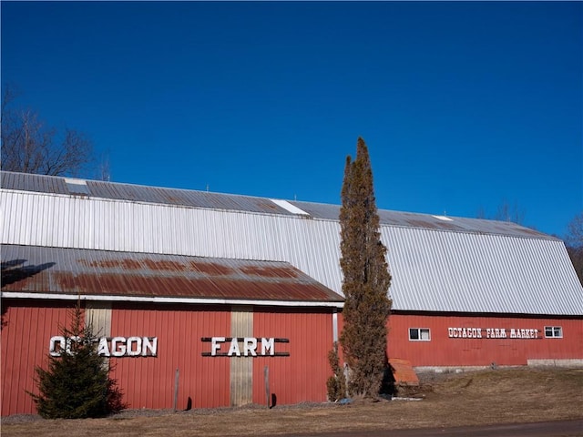 view of property exterior with an outbuilding, a detached garage, and an outdoor structure