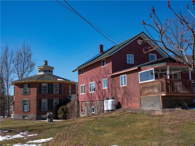 back of house featuring a chimney and a yard