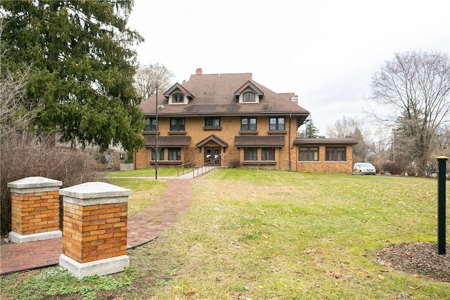 view of front facade with a front yard and a chimney