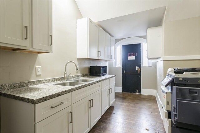 2956 Saint Paul Blvd, Irondequoit, NY 14617 - kitchen with arched walkways, dark wood-type flooring, white cabinetry, a sink, and baseboards