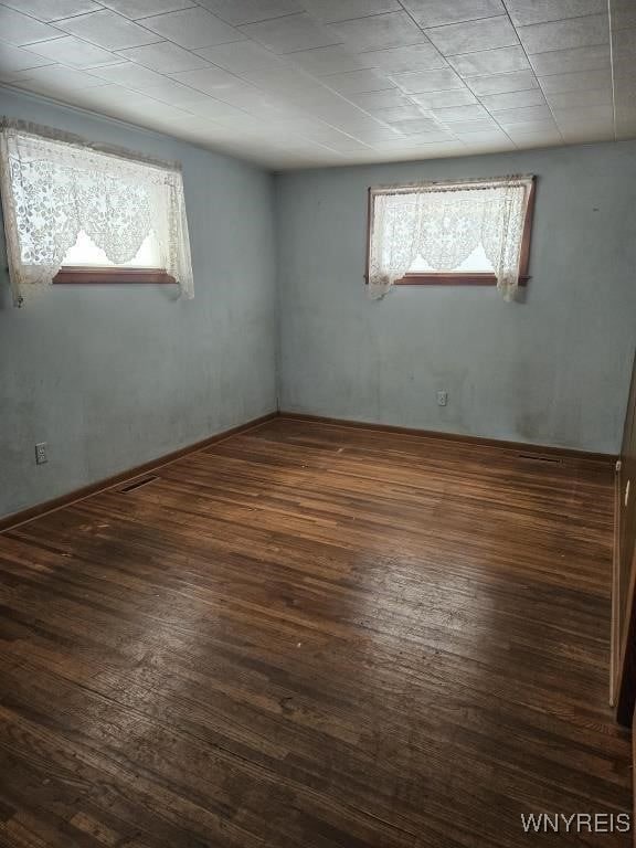 empty room featuring wood finished floors and visible vents