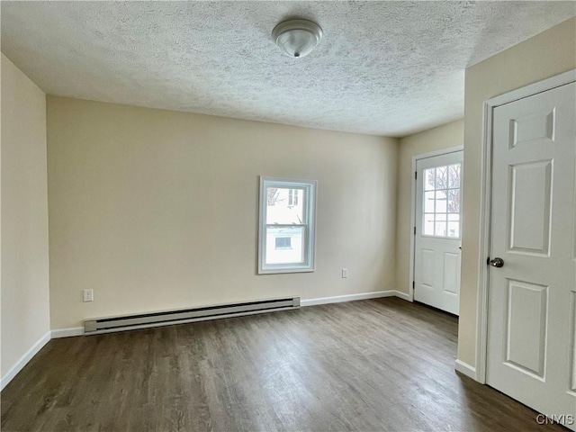 unfurnished room featuring a baseboard heating unit, dark wood-style flooring, a textured ceiling, and baseboards