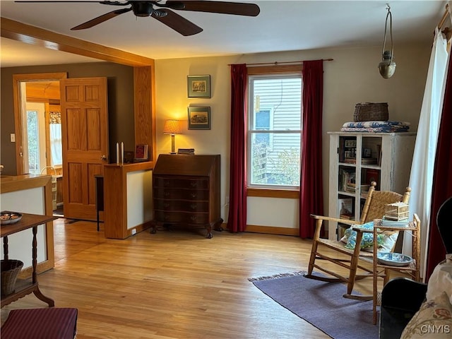 living area featuring baseboards and light wood-style floors