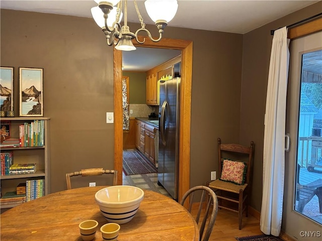 dining room with baseboards, wood finished floors, and a notable chandelier