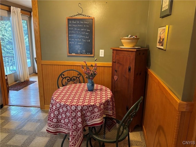 dining area featuring a wainscoted wall, wood walls, and a wealth of natural light