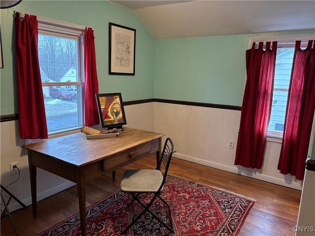 dining room featuring vaulted ceiling, wood finished floors, and baseboards