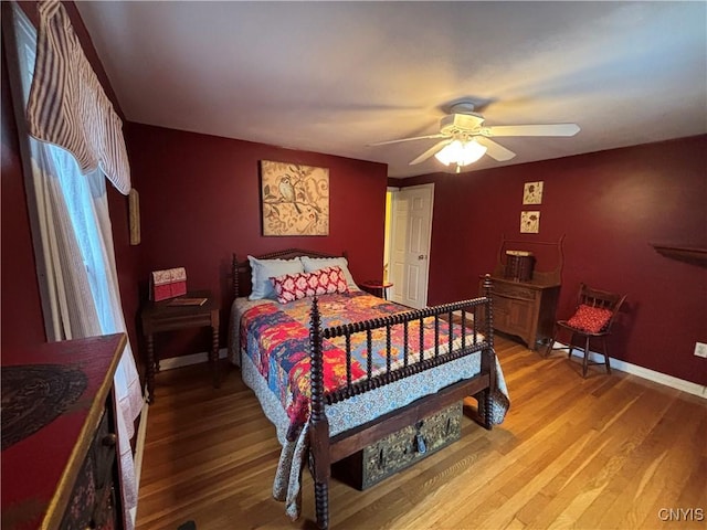 bedroom with light wood-style floors, baseboards, and a ceiling fan