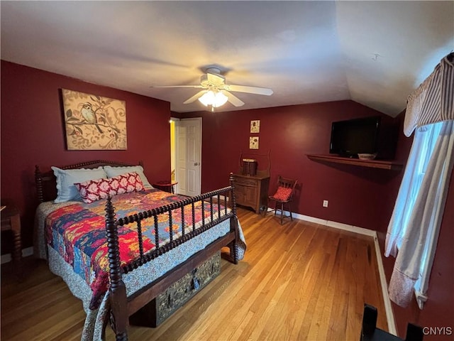 bedroom with lofted ceiling, ceiling fan, baseboards, and wood finished floors