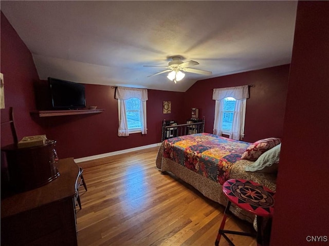 bedroom with lofted ceiling, wood finished floors, a ceiling fan, and baseboards