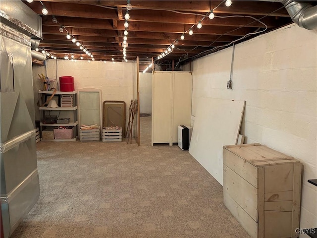 unfinished below grade area with carpet flooring and heating unit